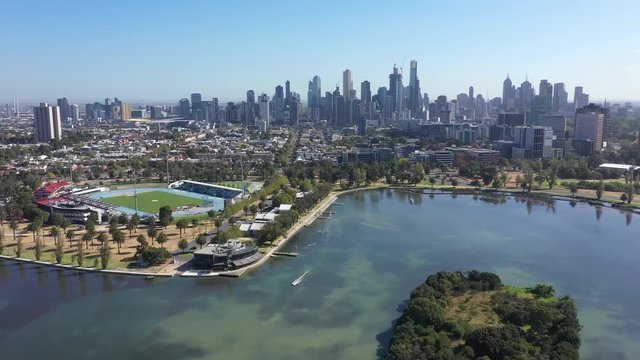 Smooth 4k footage flying over Albert Park Lake towards the city of Melbourne in the background