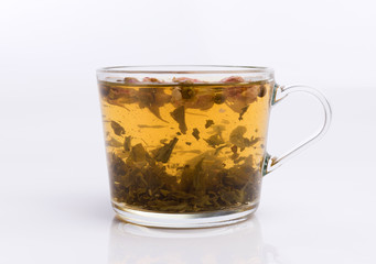 Glass cup of hot aromatic roses tea on white background