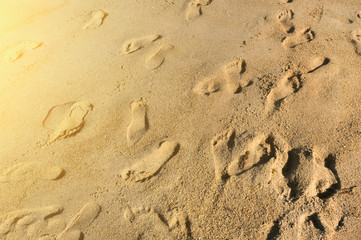 Fototapeta na wymiar Vacation concept. Foot steps on the sand at sunshine. 