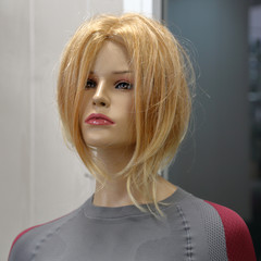 Female mannequin in a red wig to demonstrate fashionable clothes