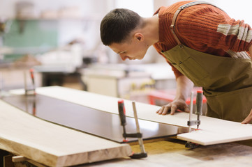 The master works on a surface grinding machine in the carpentry workshop