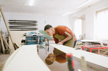 The master works on a surface grinding machine in the carpentry workshop