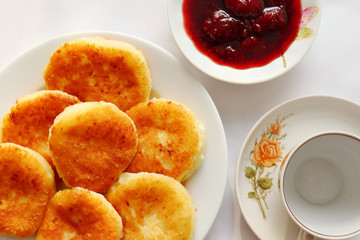 Fragrant ruddy golden with a brown crust freshly cooked syrup curds(cheesecake) with strawberry jam and sour cream piping hot.