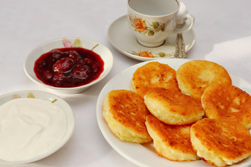 Fragrant ruddy golden with a brown crust freshly cooked syrup curds(cheesecake) with strawberry jam and sour cream piping hot.