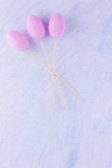 Pink Easter eggs on a stick. Easter minimal concept. Bouquet of eggs on a white background. Flat lay