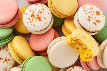 Heap of colorful macarons with various fillings.