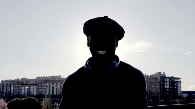 African man dancing in the sunny day. Use some headphones