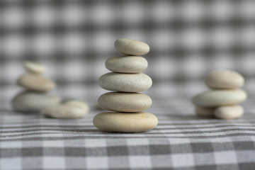 Harmony and balance, cairns, simple poise stones on white gray checkered background, rock zen sculpture, five white pebbles