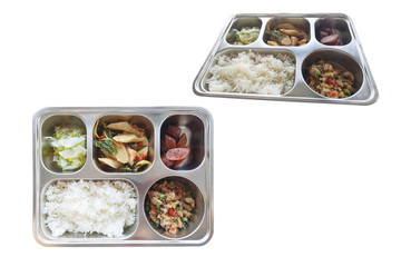 Various Thai dishes. rice, pork fried basil, stir-fried fish balls ,sausage and sweets in stainless steel food tray. Top View and side isolated on white background with clipping path.