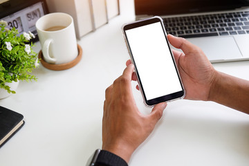 Cropped shot view of man hands holding smart phone with blank copy space screen for your text message or information content, female reading text message on cell telephone during in urban setting. © wattana
