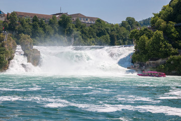 Boat with people floating to the waterfall the Rhine Falls