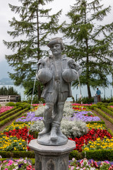 Obraz premium Sculpture in the park of Oberhofen Castle, around flowers, green trees