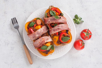 Stuffed pumpkin Butternut meat and vegetables on a plate. Lying next to a fork, tomato and spices. The view from the top.