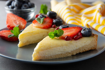 Cheesecake with fresh berries and mint for dessert - healthy organic summer dessert pie cheesecake. Cheese cake. Gray background.