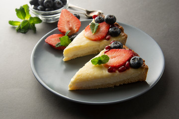 Cheesecake with fresh berries and mint for dessert - healthy organic summer dessert pie cheesecake. Cheese cake. Gray background.