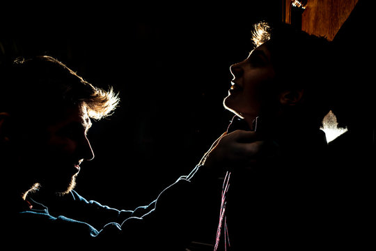silhouette of two young guys in the dark place bully and fight conception