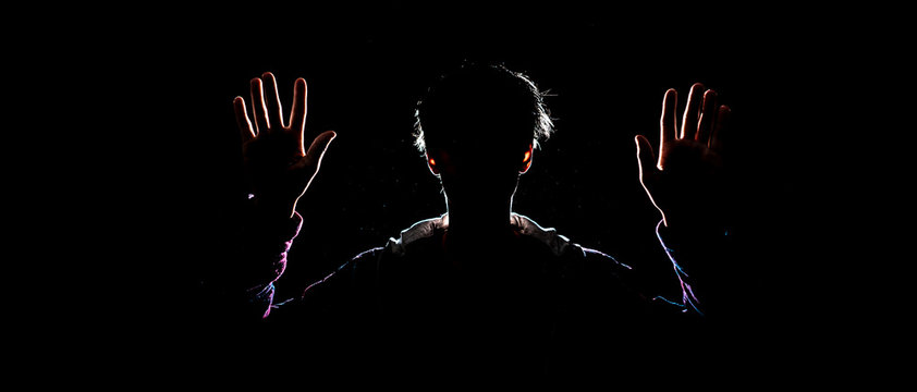 cought by police suspect with raised hands in the dark place at night