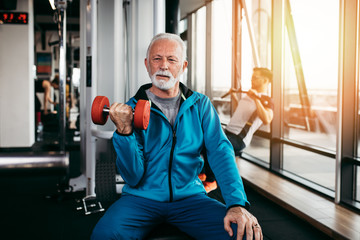 Senior man exercising at gym.