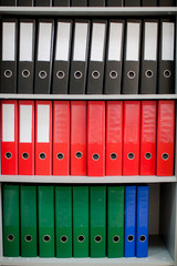 colorful archive folders for documents on the shelves in the office