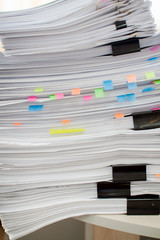 Fototapeta premium A stack of papers fastened with stationery clips and clips with stickers.