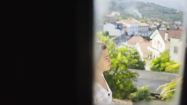 View through doors of traditional country house in valley of Douro river. Crop woman on balcony looking away on valley of Douro river, winemaking region of Portugal.