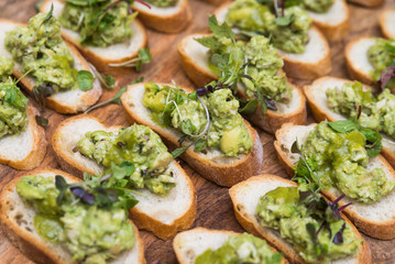 Healthy vegetarian and vegan buffet concept nutritious snack platter crispy bread slices with avocado and fresh sprouts on wooden board