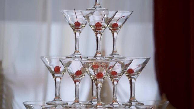 Champagne pyramid for parties with cherries and dry ice. Backlit table
