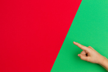 Hand pointing a finger on green and red color background