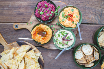 four dips served on a rustic platter