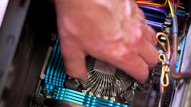 Close-up of the hand of the service man uninstall the radiator of the CPU. Personal computer repair