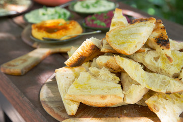Rustic toasted bread platter with dips served outside