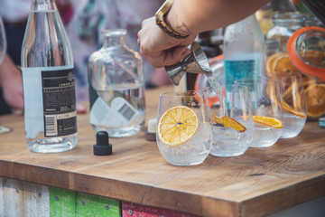 Bartender Pouring a gin and tonic cocktail - obrazy, fototapety, plakaty