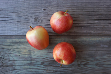3 fresh red apples on the old wooden surface. Fruit harvest. 