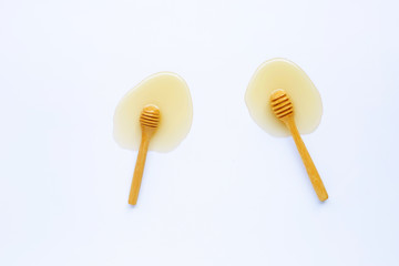 Wooden dipper and honey on white.