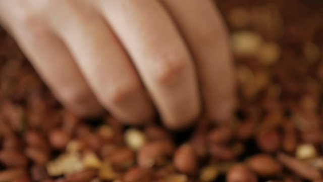 Man cleans roasted peanuts. Close-up.