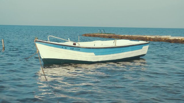 Small fiber-glass boat anchored at beautiful holiday wanderlust seaside resort.