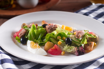 Mediterranean cuisine. Tuna slices with fresh vegetable salad on a plate. Top view