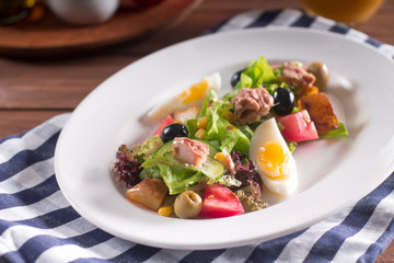 Mediterranean cuisine. Tuna slices with fresh vegetable salad on a plate. Top view