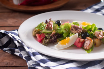 Mediterranean cuisine. Tuna slices with fresh vegetable salad on a plate. Top view