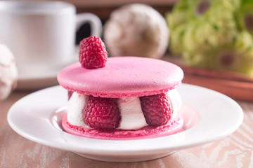 Pink macarons with vanilla cream, fresh raspberries