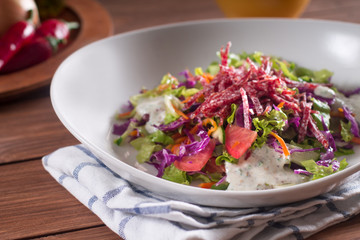 Mediterranean cuisine. Fresh salad with arugula, tomatoes, red cabbage, cucumber and yogurt sauce