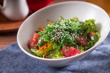 Traditional Japanese salad. With seaweed, fresh herbs, tomatoes, cucumbers, carrots, sesame
