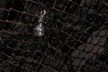 The incandescent lamp hangs in the tunnel of an old abandoned coal mine.