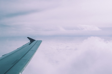 Fototapeta na wymiar Airplane wing over sea of white clouds over Poland. Romantic dreamy view. 