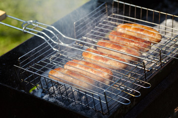 rubicund sausages are roasted on coals. Barbecue on grill in smoke
