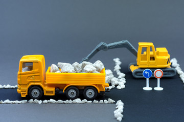 Diorama road construction with yellow construction machinery models. Construction concept....