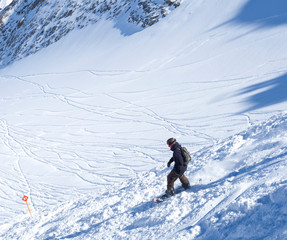 KAPRUN, AUSTRIA, March 12, 2019: Free ride piste with freerider snowboarder skiing downhill on snow...