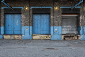 Blue doors with lights on the back of a vintage abandoned warehouse