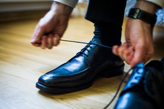 Man lace up shoe in his wedding day.