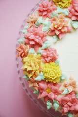 cake with cream flowers on pink background